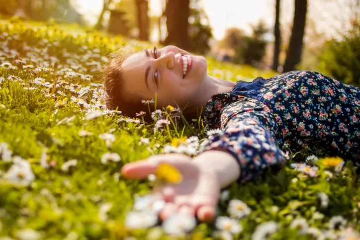 Personne détendue allongée dans l’herbe après avoir soulagé ses troubles digestifs naturellement